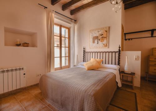 a bedroom with a bed and a window at Can Bagot, Turismo de Interior in Llubí