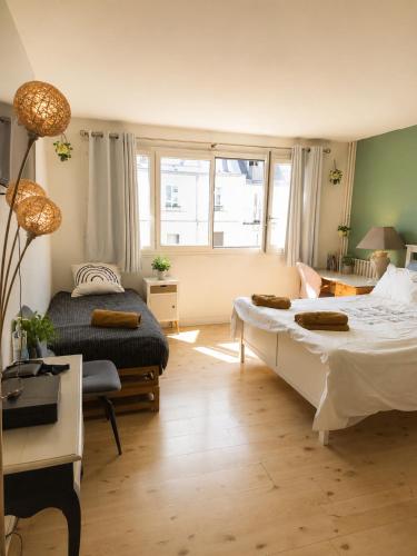 a bedroom with two beds and a couch and a table at Spacious Studio Paris La villette-Metro in Paris