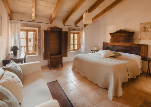 a bedroom with a large bed and a couch at Can Bagot, Turismo de Interior in Llubí