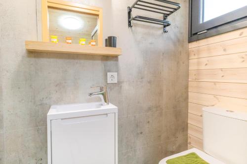 a bathroom with a white sink and a toilet at Naturverliebt am Diemelsee - Tiny House Wiesenblick in Heringhausen