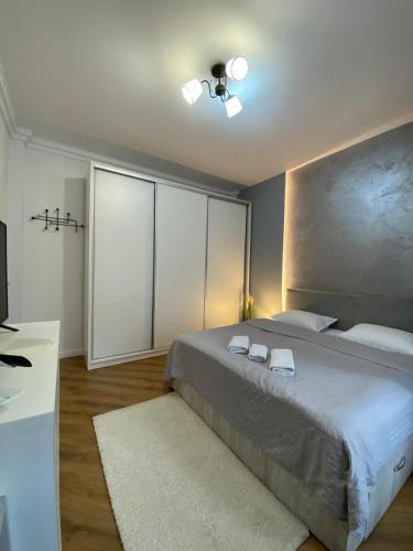 ein Schlafzimmer mit einem Bett, auf dem zwei Handtücher liegen in der Unterkunft M&M Apartments CSV Home in Cluj-Napoca