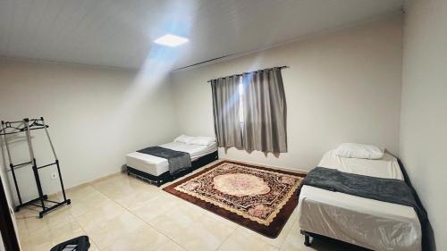 a small room with two beds and a window at Casa California - espaçosa in Formosa