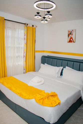 a bed with a yellow blanket on top of it at executive home in Eldoret