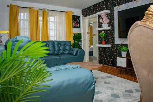 a living room with a blue couch and a tv at executive home in Eldoret