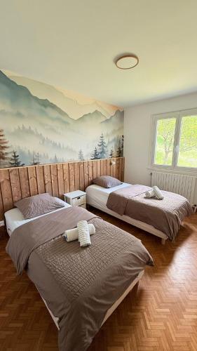 two beds in a bedroom with a painting on the wall at Le Repère De lAigle - Vue Panoramique in Cornimont