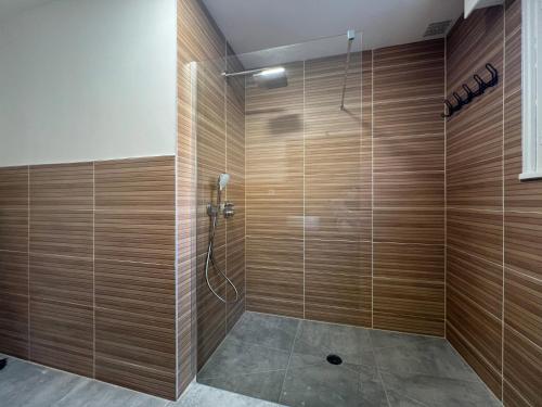 a bathroom with a shower with wooden walls at Le Repère De lAigle - Vue Panoramique in Cornimont