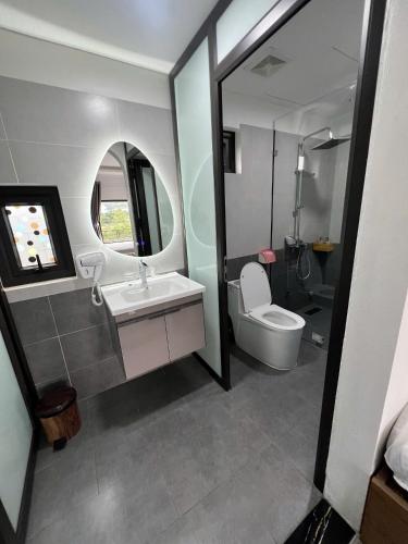 a bathroom with a toilet and a sink and a mirror at Bazan Home Mộc Châu in Mộc Châu