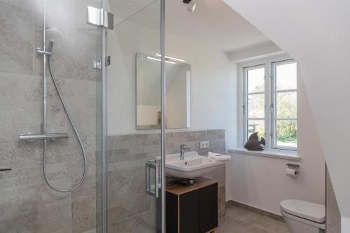 a bathroom with a sink and a shower at Friesenfrühling in Borgsum