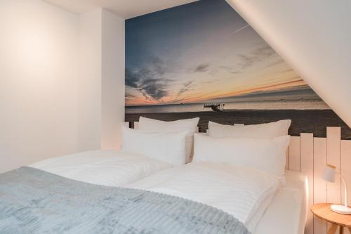 ein Schlafzimmer mit einem Bett und Blick auf den Strand in der Unterkunft Sommergeest in Borgsum