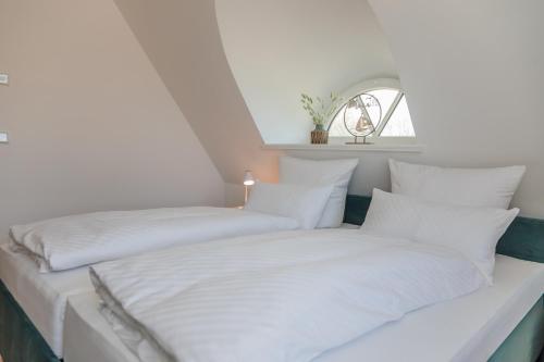 two beds sitting next to each other in a bedroom at Reetruhe in Borgsum