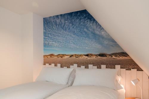 a bedroom with a wall mural of a beach at Wattenkieker in Borgsum