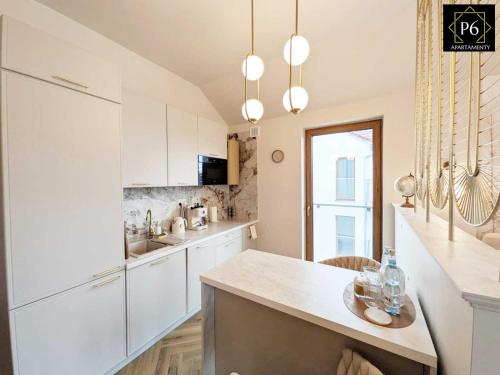 a kitchen with white cabinets and a counter top at P6 Apartament Kaszmirowy in Pisz