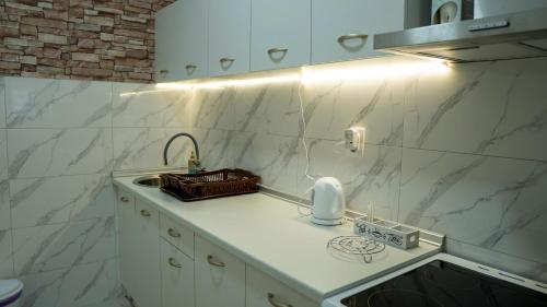 a kitchen with white marble walls and a sink at Apartman M&Ð Foca-free parking garage in Foča