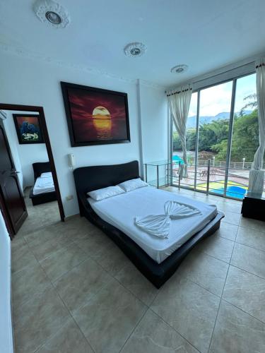 a bedroom with a bed and a large window at Hotel Cristalina in Melgar