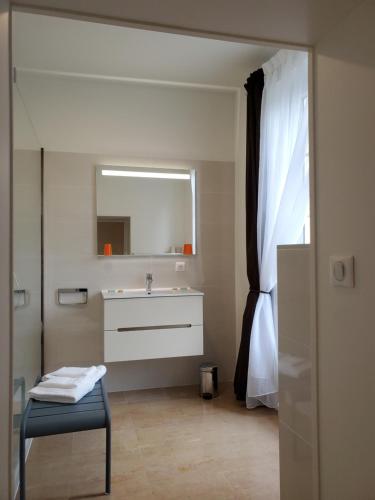 a bathroom with a sink and a mirror at Logis des Tourelles in Cognac