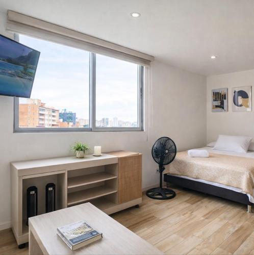 a bedroom with a bed and a large window at Beautiful Apto in Poblado in Medellín