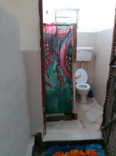 a bathroom with a painting on the shower door at Mango Lodge MSAMBWENI in Kisimachande