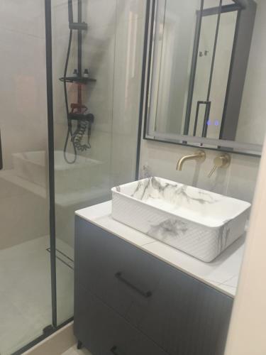 a bathroom with a white sink and a shower at Современные 2-комнатные апартаменты в ЖК Capital City рядом с Shym City Park in Shymkent