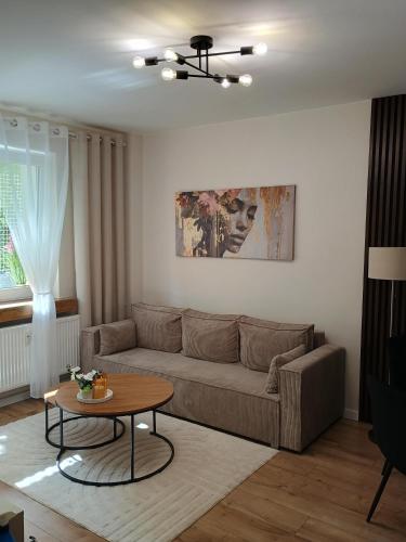 a living room with a couch and a table at Vespera Apartment - Retkinia in Łódź