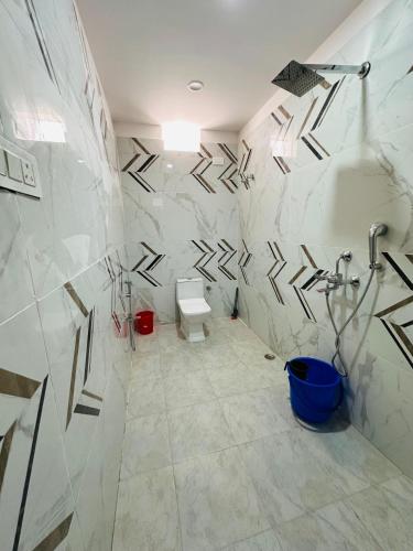 a bathroom with a toilet and a shower at HOTEL Blue Fin in Rānchī