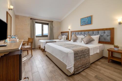 a hotel room with two beds and a flat screen tv at Gokceada Surf Egitim Merkezi in Gokceada Town