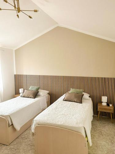 a bedroom with two beds and a striped wall at Casa Vacanze Francesca in Mondolfo