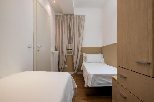 a hotel room with two beds and a dresser at Leoncino Apartment in Verona