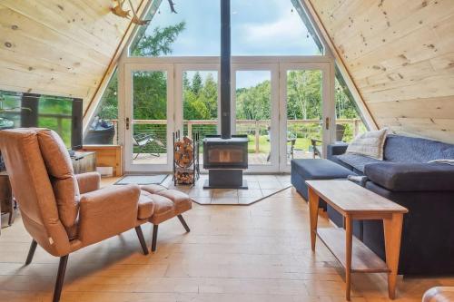 a living room with a couch and a fireplace at Chalet au Bord de l'Ecluse in Brébeuf