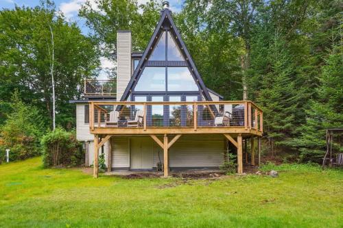 a house with a gambrel roof with a deck at Chalet au Bord de l'Ecluse in Brébeuf