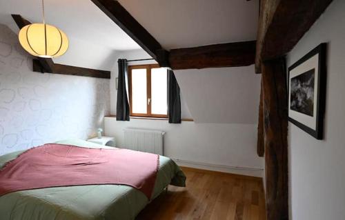 a bedroom with a bed in a room with a window at Gîte à l'origine in Montgesoye