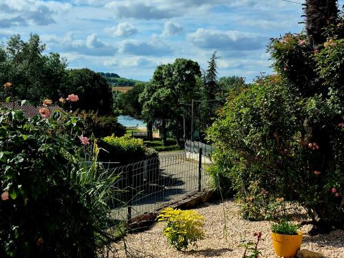 a garden with a fence and some bushes and flowers at Lake Villa Castéra-Verduzan in Castéra-Verduzan