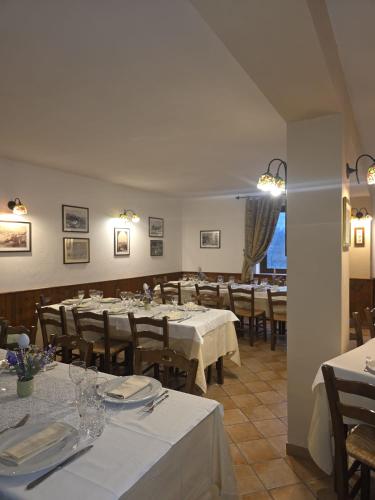 a dining room with tables and chairs with white tablecloths at hotel il ghiro in Ovindoli