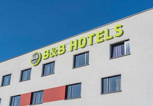 a building with a big ben hotel sign on it at B&B HOTEL Brumath Bernolsheim in Brumath