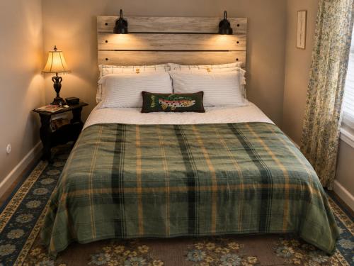a bedroom with a large bed with a plaid blanket at Mt Shasta Basecamp in Dunsmuir