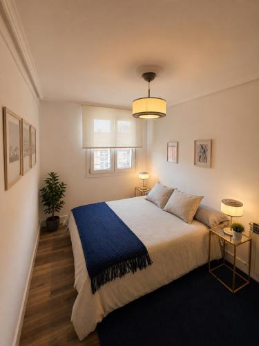 a bedroom with a large bed with a blue blanket at Hauda in Sopelana