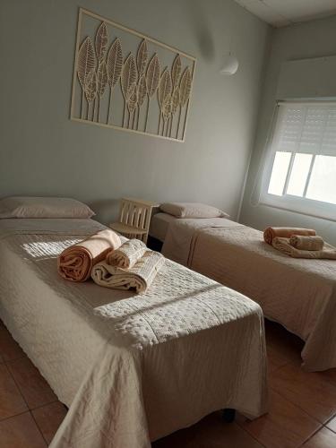 two beds in a room with towels on them at Con alma de Paraná, patio y estacionamiento propio in Paraná