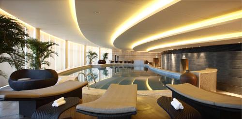 a hotel lobby with a swimming pool in a building at Tangla Hotel Tianjin in Tianjin