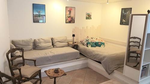 a bedroom with two beds and a chair at La chambre d'hôtes du moulin de Vignars in Ginals