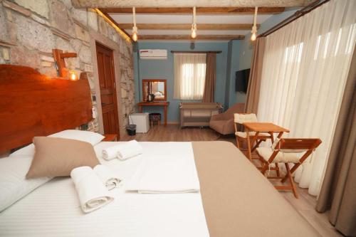 a bedroom with a bed and a table and chairs at Lotus Konaklama Küçükköy in Ayvalık