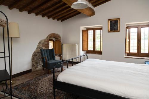 a bedroom with a bed and a table and a chair at Mulino di Pari - Where Time Slows in Pari