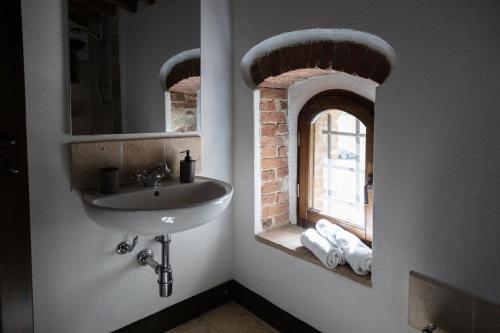 a bathroom with a sink and a window at Mulino di Pari - Where Time Slows in Pari