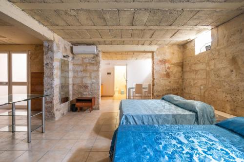 a large bedroom with two beds and a table at Biancolino Apartments in Nardò