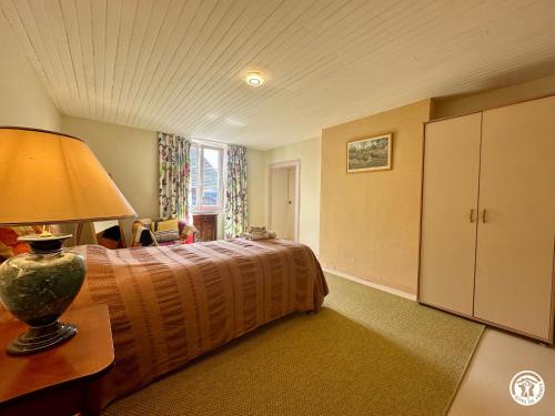 a bedroom with a bed and a lamp on a table at Gîte Geoffroy in Montigny-sur-Aube