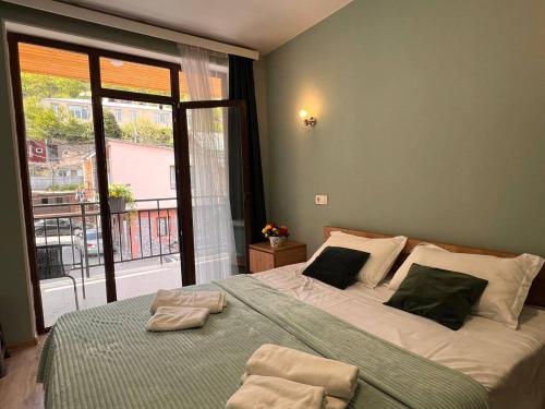 a bedroom with a large bed with two towels on it at Memory- borjomi in Borjomi