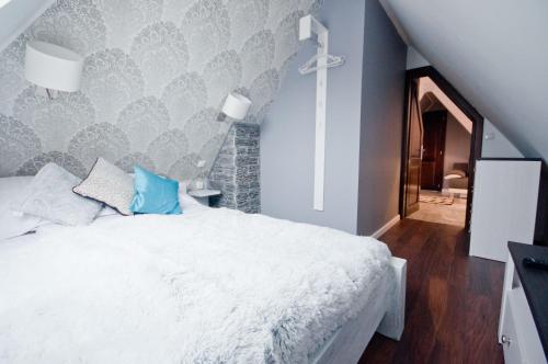 a bedroom with a white bed and a blue wall at U Hanki in Biały Dunajec