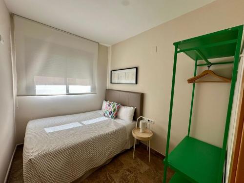 a small bedroom with a bed and a green ladder at Apartamentos Plaza Picasso in Valencia