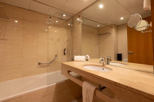 a bathroom with a sink and a shower and a tub at THE Hotel MASA Almirante LISBON Stylish in Lisbon