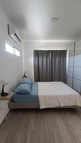 a bedroom with a large bed with blue pillows at One suite los corales in Punta Cana