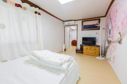 a bedroom with two beds and a television in it at Najoo sunflowerstay in Naju
