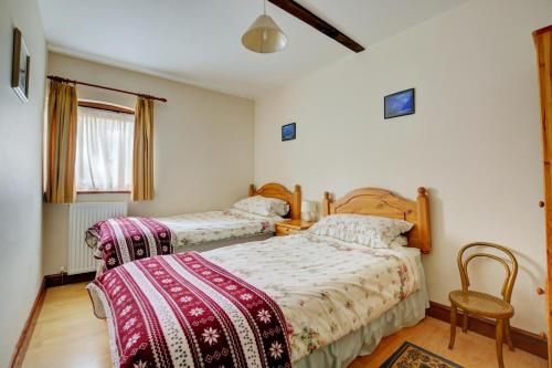 a bedroom with two beds and a chair at 2 Bed in Lyng oc-864 in Lyng
